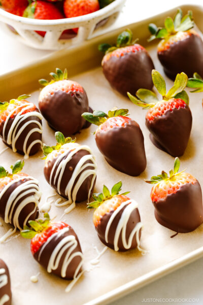 Chocolate covered strawberries on a baking sheet.