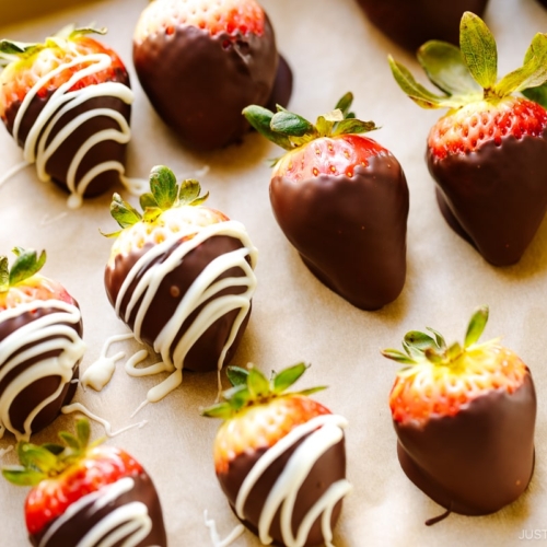 Chocolate covered strawberries on a baking sheet.