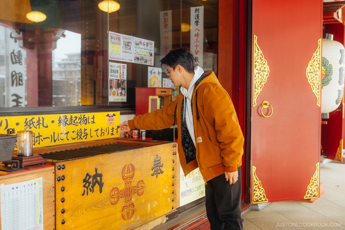 Placing money in temple offering box