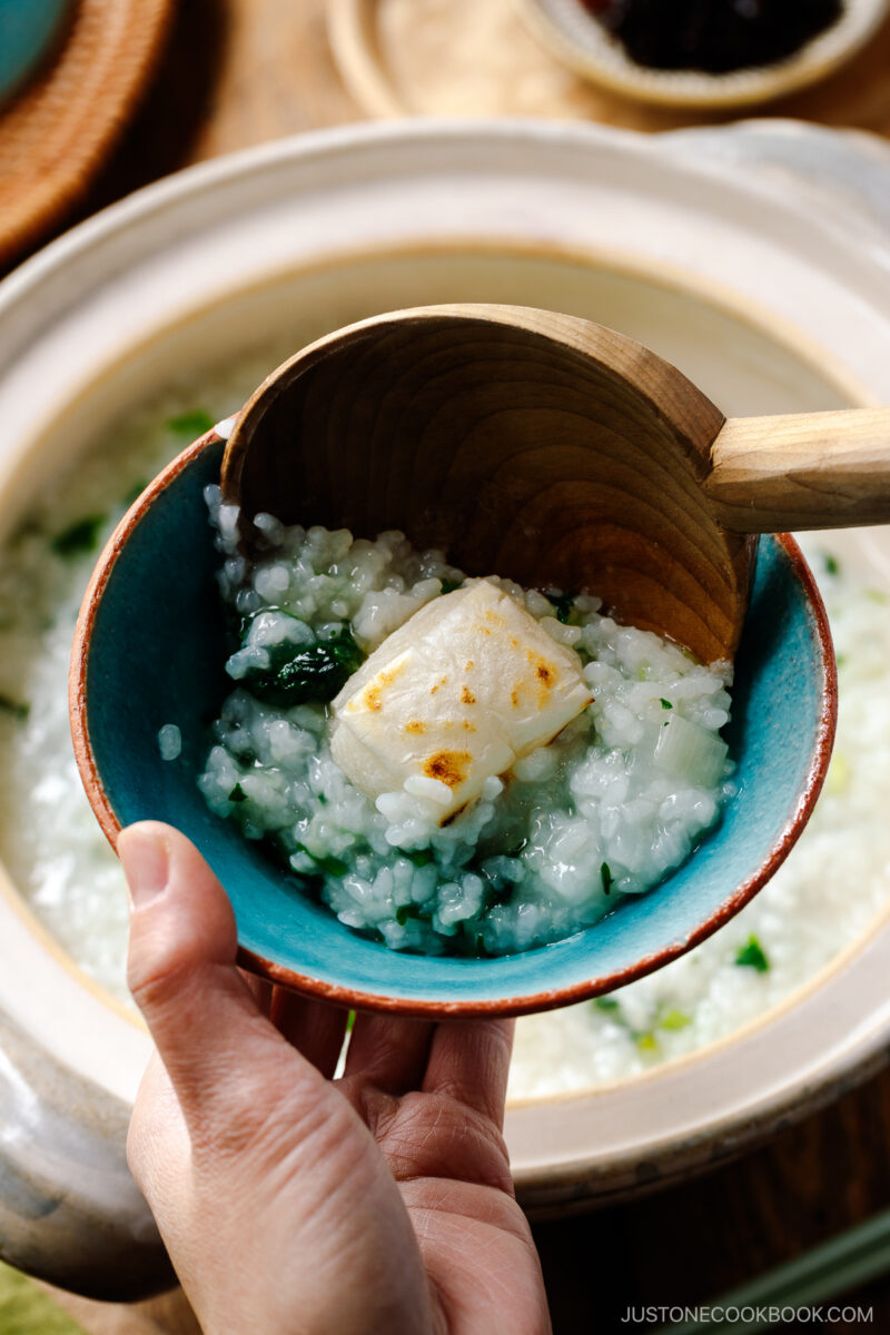 A blue rice bowl containing Nanakusa Gayu, Japanese seven herb rice porridge.