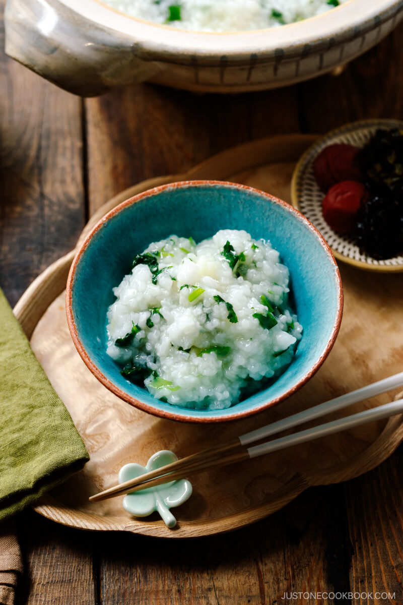 A blue rice bowl containing Nanakusa Gayu, Japanese seven herb rice porridge.
