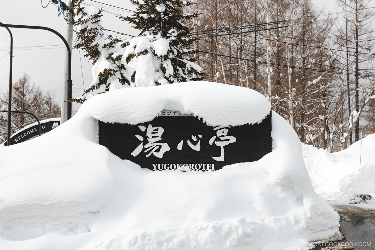 Yugokorotei Onsen Ryokan sign covered in snow