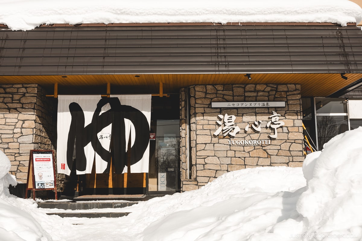 Yugokorotei Onsen Ryokan sign covered in snow