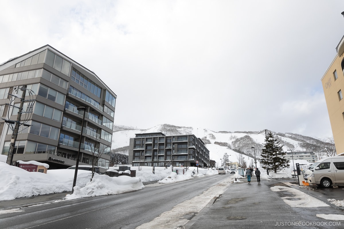 people walking in Niseko next to new hotels