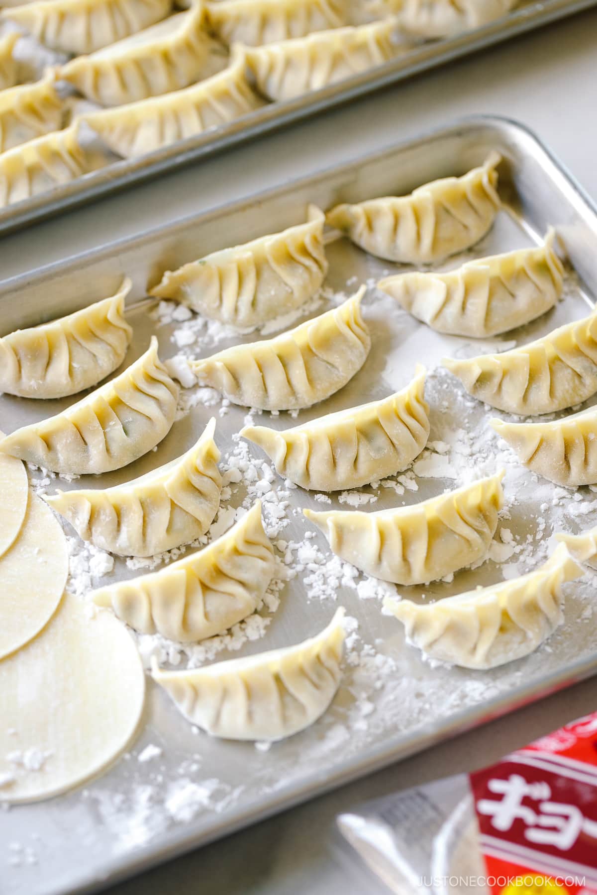 A baking sheet containing perfectly wrapped gyoza.