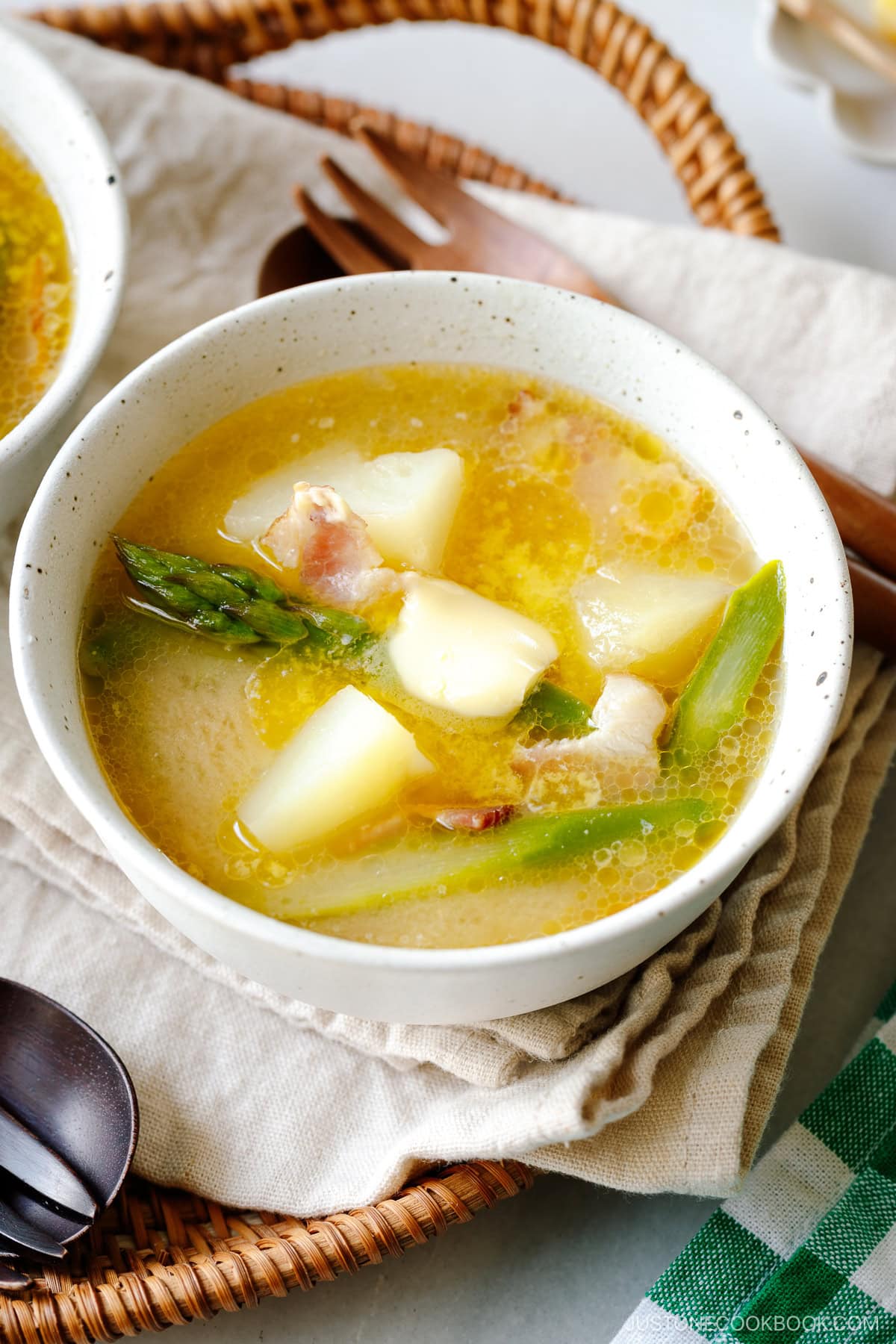 White ceramic bowls containing Bacon Asparagus Miso Soup topped with a slice of butter.