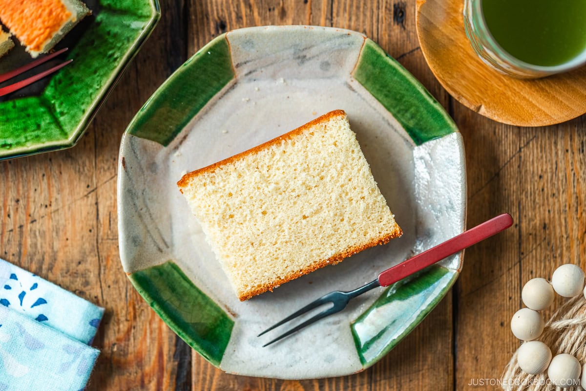 An octagon plate containing a slice of Castella cake.