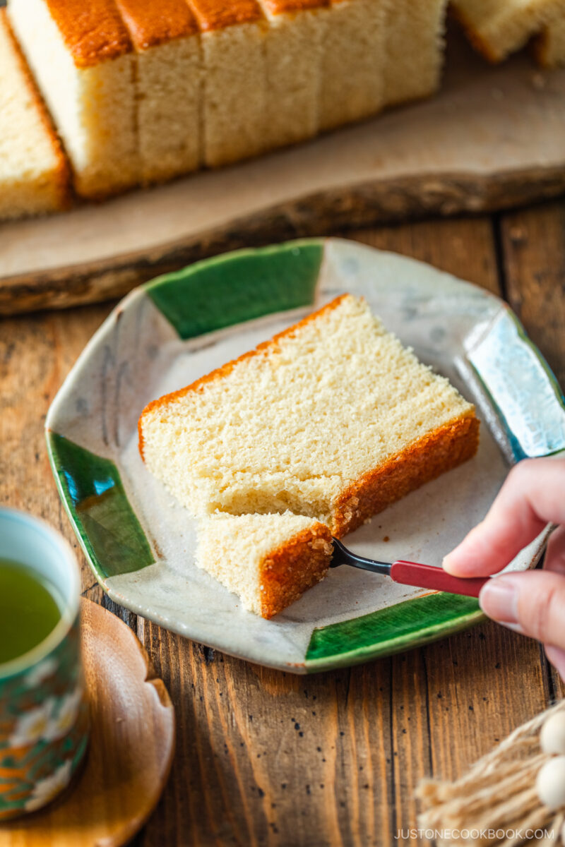 An octagon plate containing a slice of Castella cake.