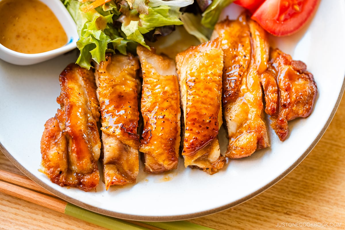 A round plate containing Chicken Teriyaki glazed with homemade teriyaki sauce.