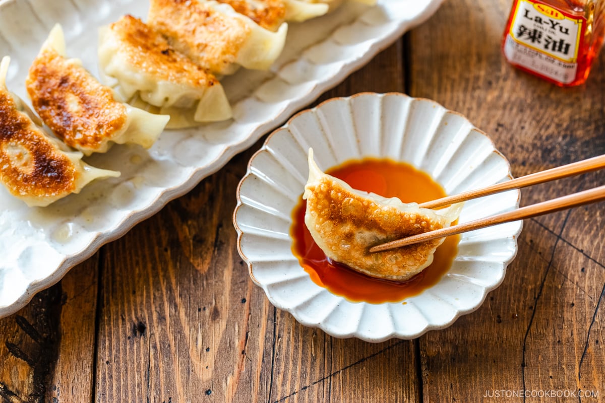 Gyoza in dipping sauce made with soy sauce, vinegar, and Japanese chili oil.