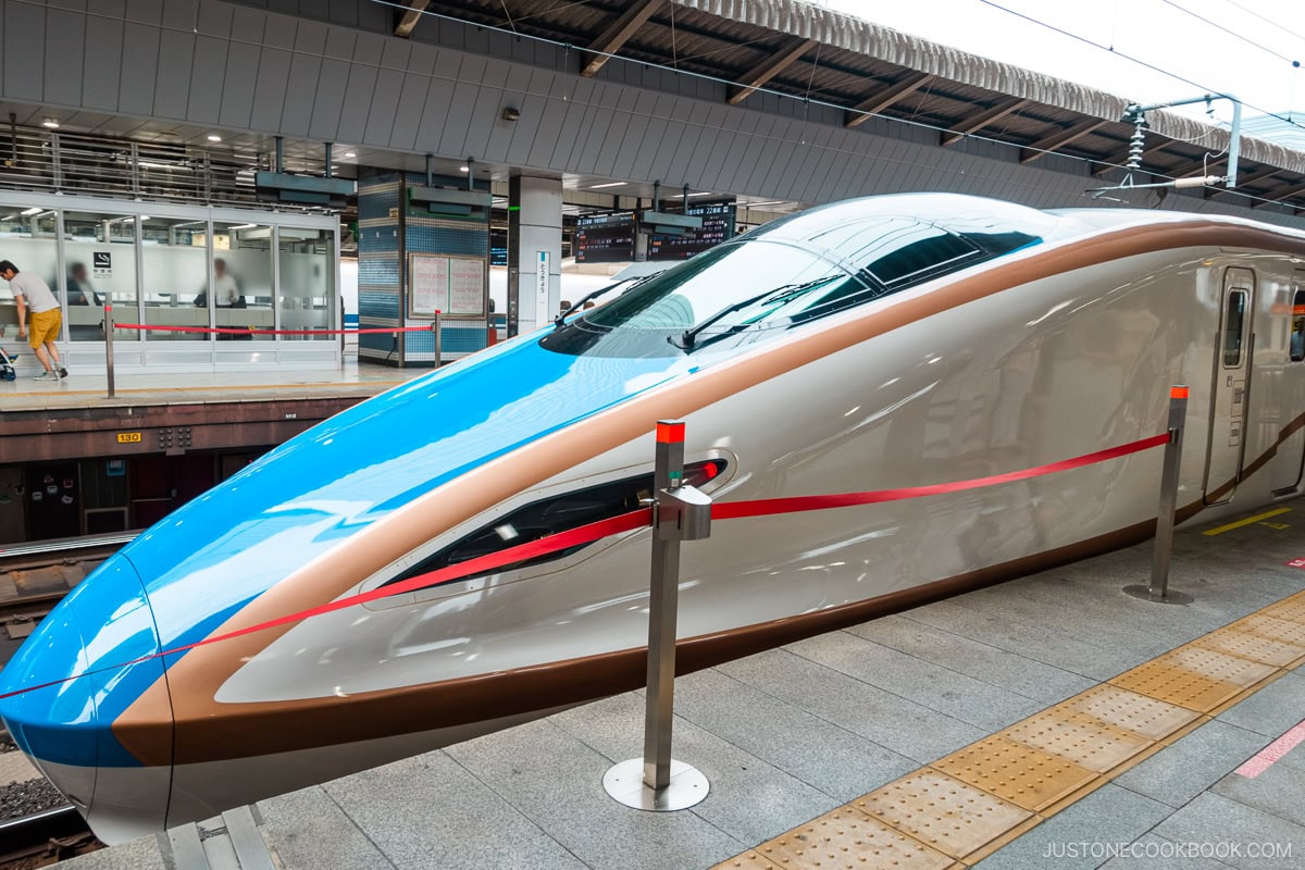 a blue and gold Shinkansen