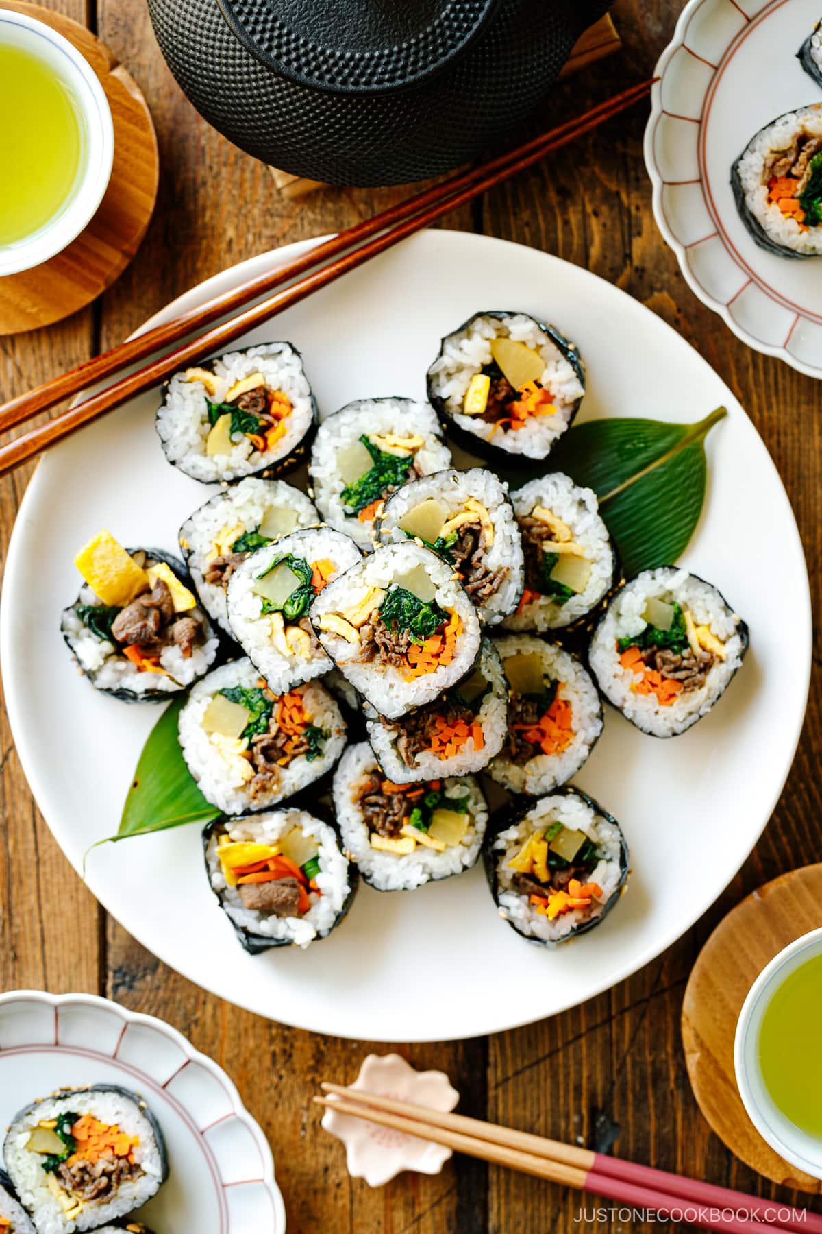 A white round plate containing sliced Kimbap (Korean Seaweed Roll).