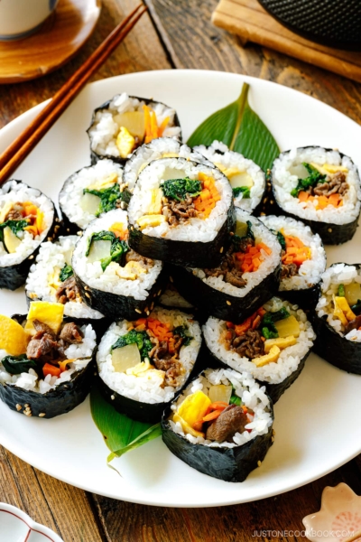 A white round plate containing sliced Kimbap (Korean Seaweed Roll).