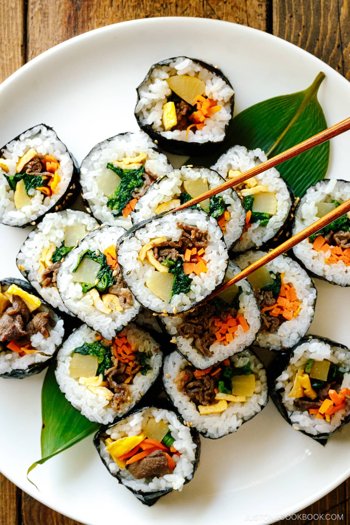 A white round plate containing sliced Kimbap (Korean Seaweed Roll).