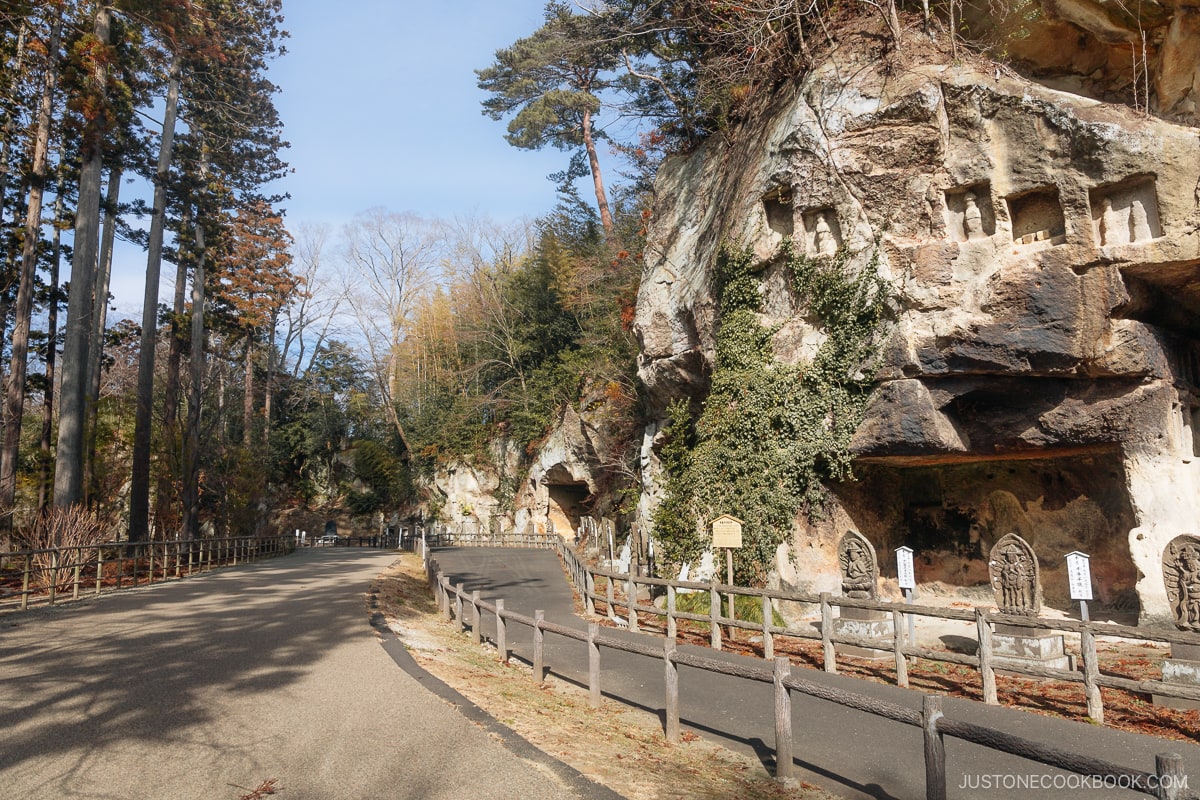 Rock cliff with Buddha statues and stone stupas