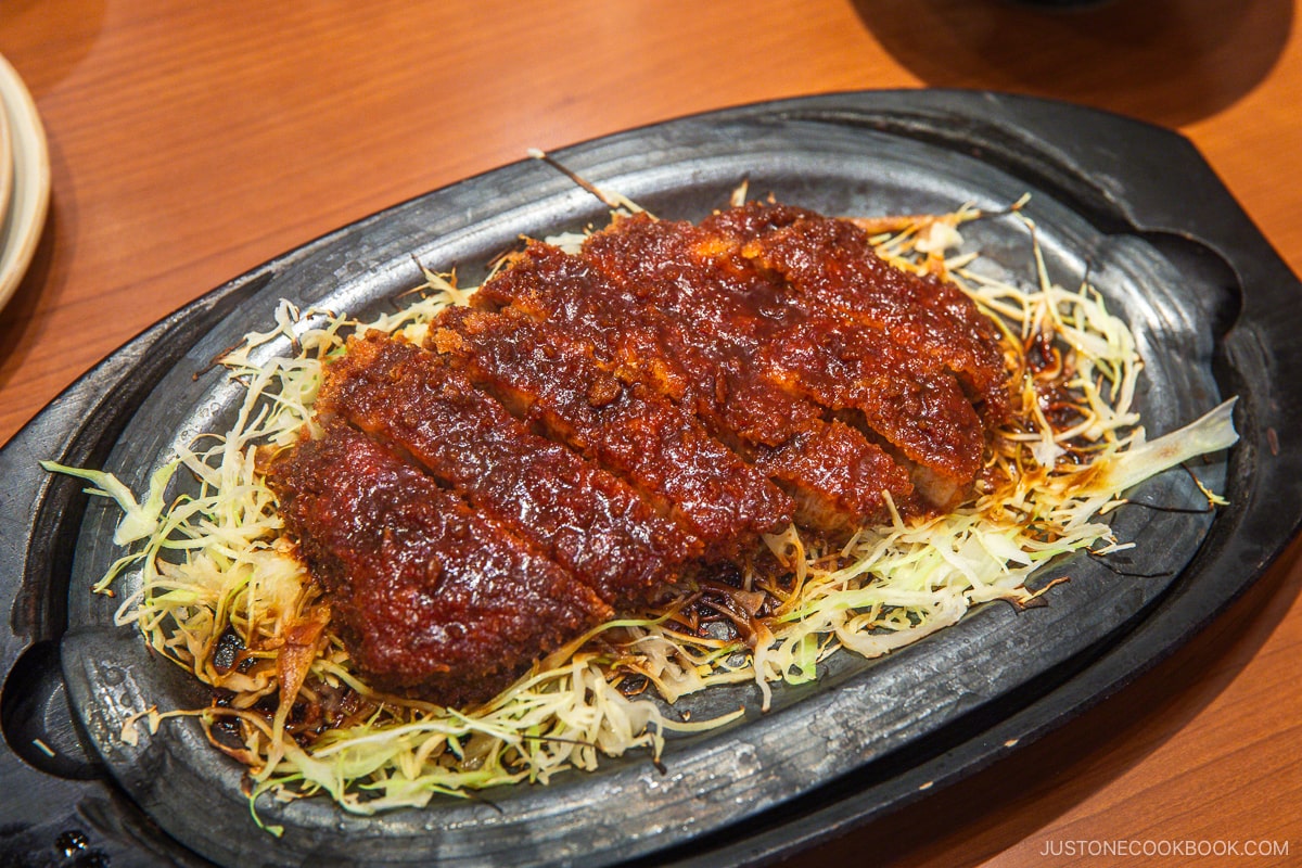 Miso katsu with shredded cabbage on a cast iron skillet