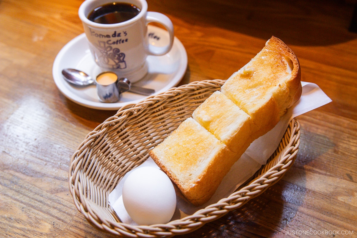 Slice of thick toast with butter, hard-boiled egg, and a cup of coffee