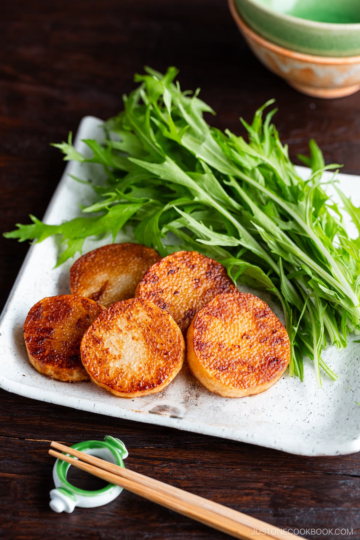 A square white plate contaning Sauteed Yam, which is simply cooked in a frying pan and coated with soy sauce.