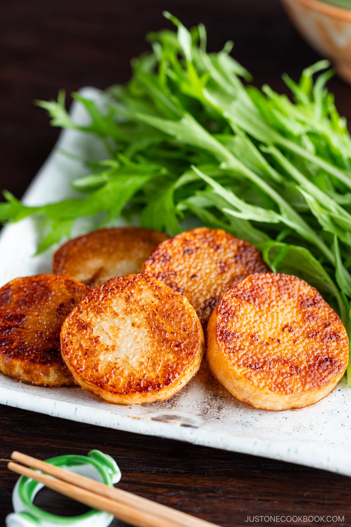 A square white plate contaning Sauteed Yam, which is simply cooked in a frying pan and coated with soy sauce.