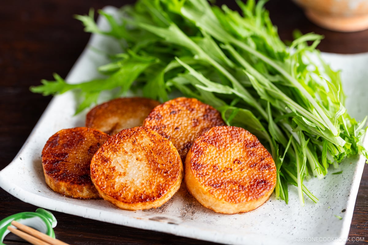 A square white plate contaning Sauteed Yam, which is simply cooked in a frying pan and coated with soy sauce.