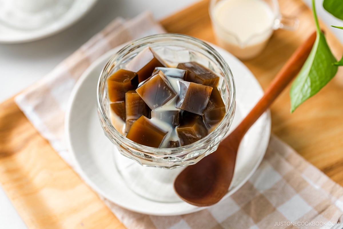 A glass bowl containing cubed Hojicha Jelly drizzled with sweetened condensed milk.