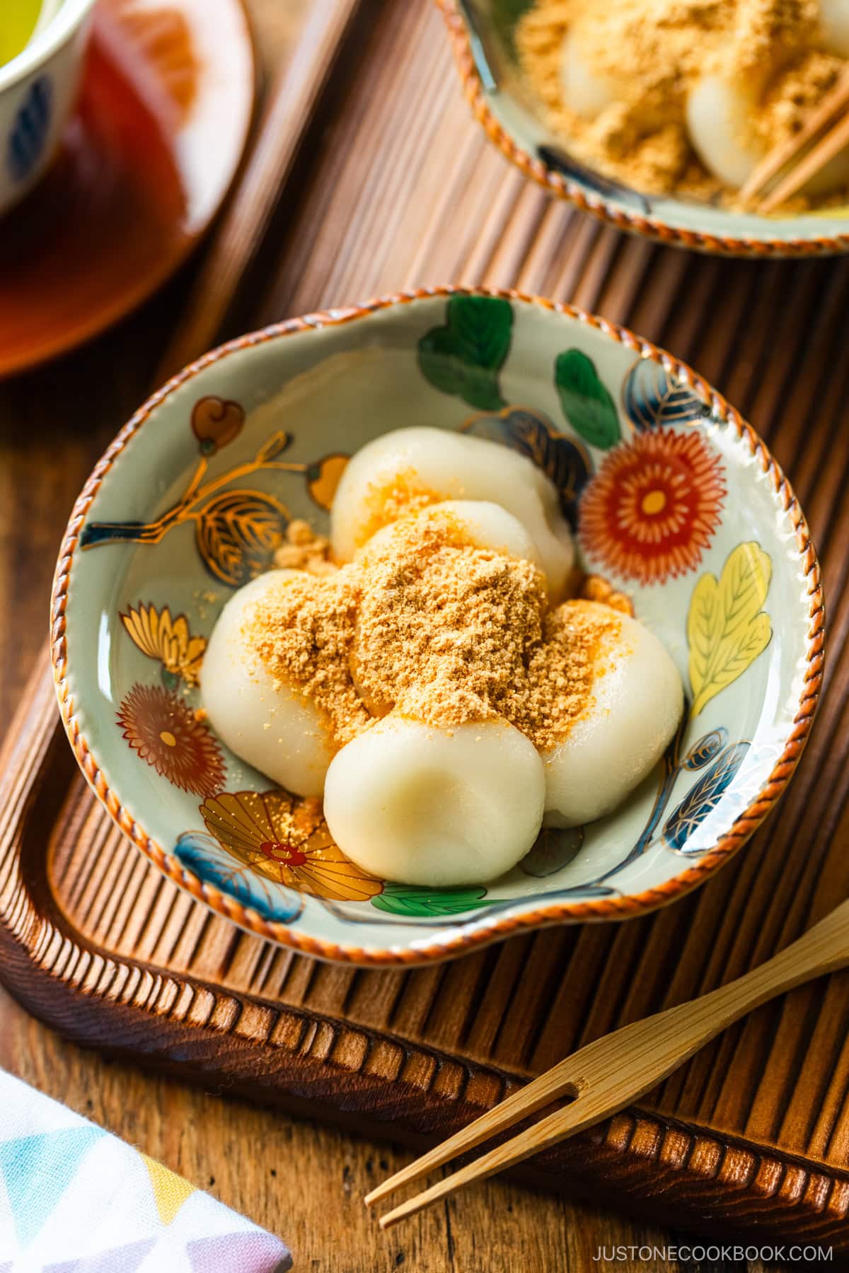 Japanese bowls containing shiratama dango dusted with sweetened kinako (soybean flour) on top.