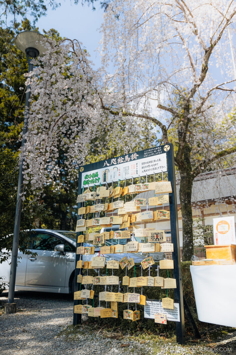 Wooden ema under a cherry blossom tree