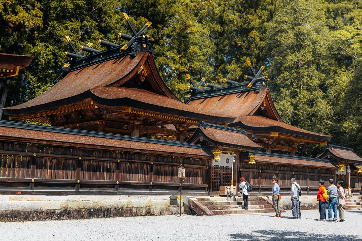 People praying at a wooden shrine