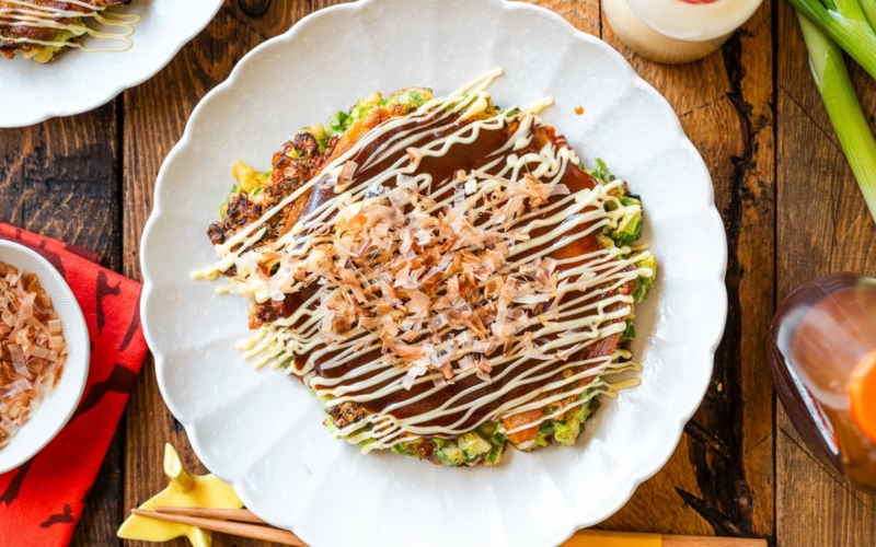 White scalloped plates containing negiyaki, a savory Japanese scallion pancake.