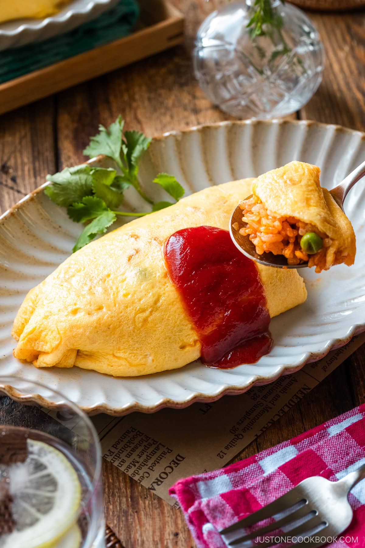 An oval plate containing Omurice (Japanese Omelette Rice) drizzled with Japanese ketchup.