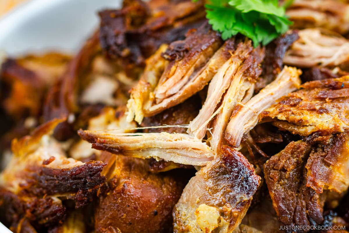 A white bowl containing Beer-Braised Carnitas.