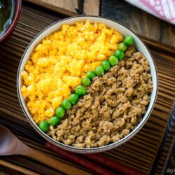 A bowl containing Soboro Don (seasoned ground chicken and scrambled egg over rice).