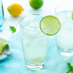 A glass filled with Japanese Yuzu Cocktail (Yuzu Chuhai) garnished with a slice of lime.