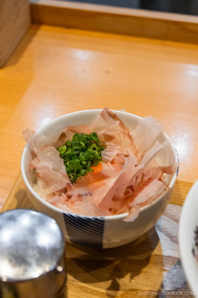 Rice topped with freshly shaved bonito flakes and raw egg yolk