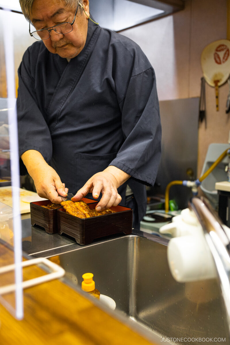 Chef laying unagi on rice