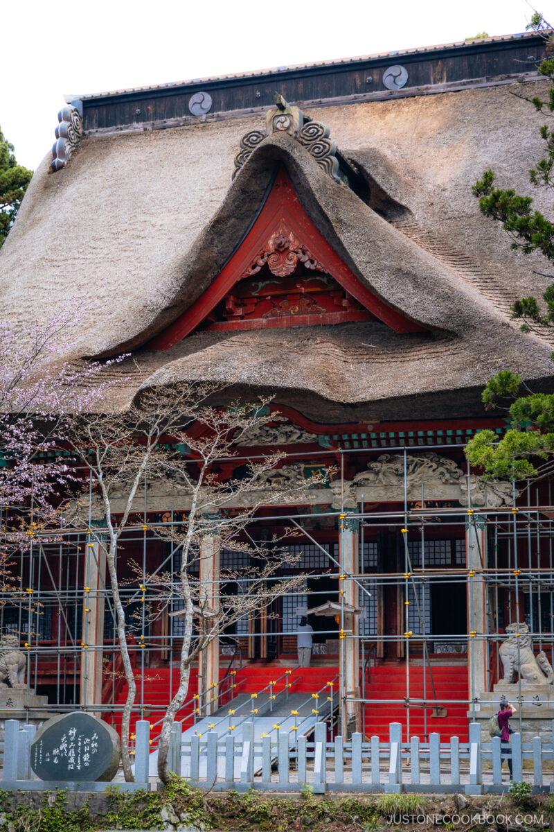 Red shrine hall with thatched roof