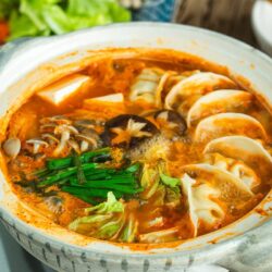 Kimchi Gyoza Nabe served in donabe (Japanese earthenware pot).