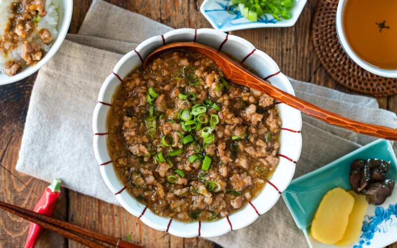 A round bowl containing Niku Miso, a savory Japanese ground pork dish seasoned with miso, mirin, and aromatics.