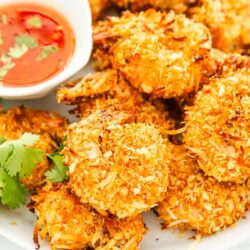 Coconut shrimp with sauce on a white plate.