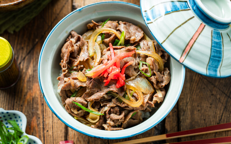 A donburi rice bowl containing gyudon, simmered beef and onions over steamed rice.