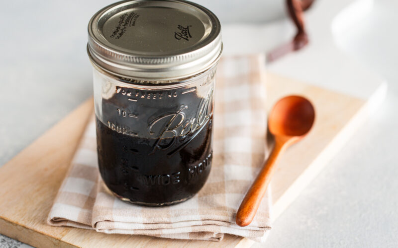A glass mason jar containing homemade teriyaki sauce.