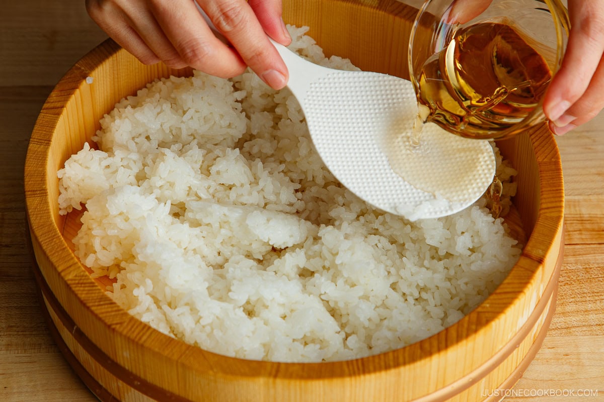 Pour the sushi vinegar over the cooked rice.