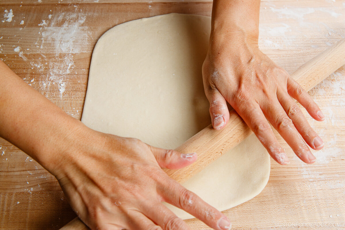 Flatten the dough with your hand on a work surface dusted with potato starch. Roll it out into a rectangle. It should be ⅛ inch (3 mm) thick and 10–12 inches long.