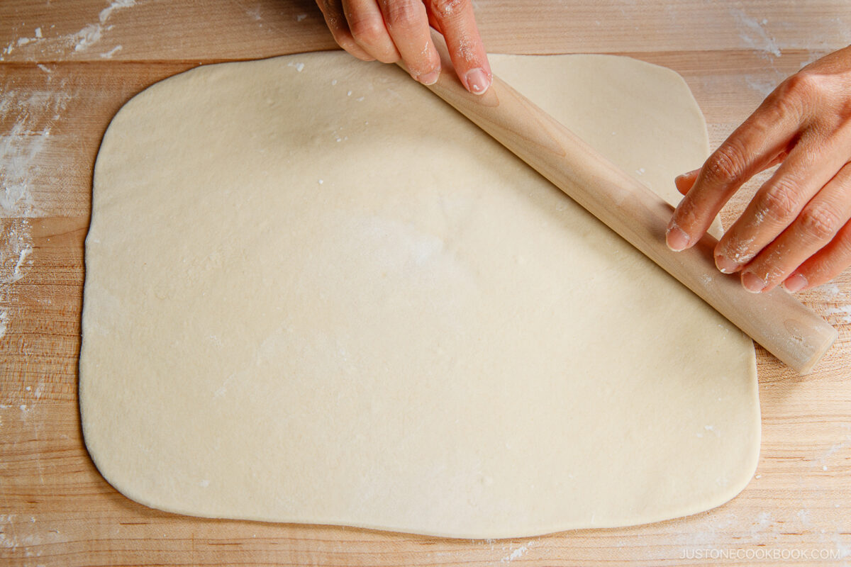 Flatten the dough with your hand on a work surface dusted with potato starch. Roll it out into a rectangle. It should be ⅛ inch (3 mm) thick and 10–12 inches long.