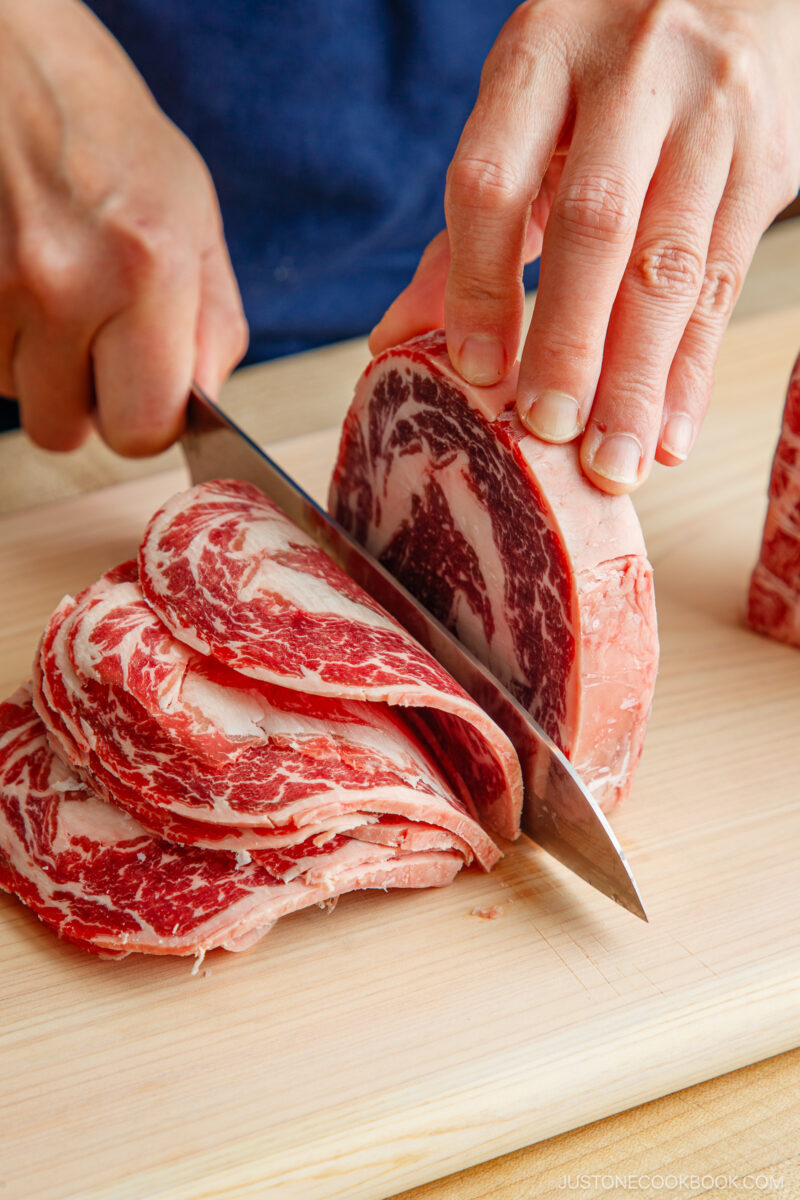 Slicing the block of the ribeye and filet mignon thinly.
