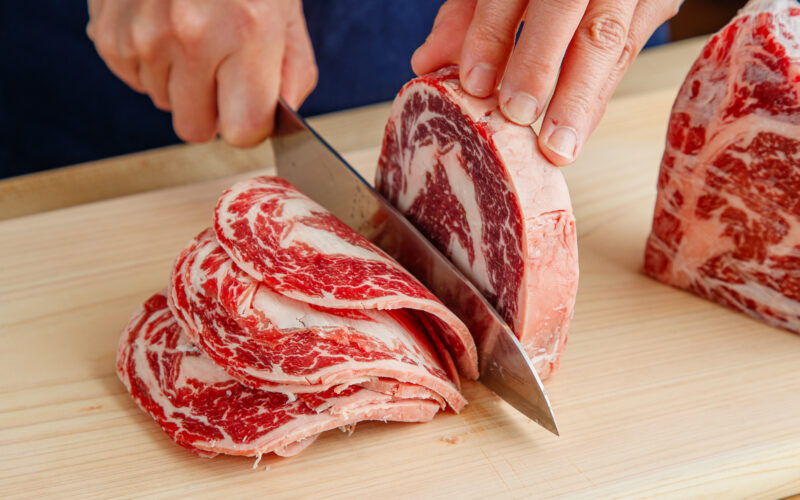 Slicing the block of the ribeye and filet mignon thinly.