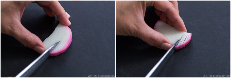 Close-up of hands holding a slice of fish cake and making fine cuts with a knife on a dark surface, preparing the ingredient for cooking.