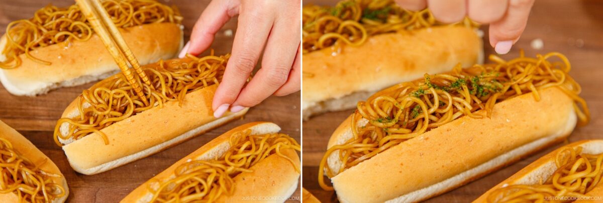 Close-up of hands placing seasoned noodles into hot dog buns with chopsticks, creating unique yakisoba pan sandwiches on a wooden surface.