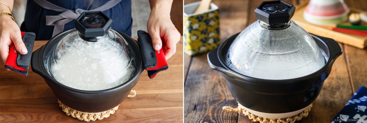 A person wearing red oven mitts holds a steaming black clay pot, demonstrating how to cook rice in a donabe, while an identical pot rests on a wooden table.