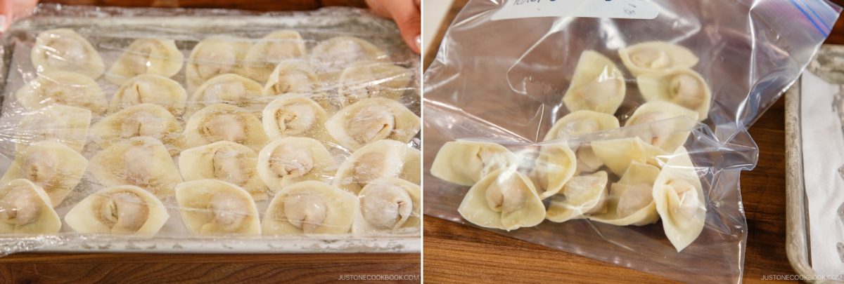 A tray of uncooked dumplings for a wonton soup recipe, covered with plastic wrap, sits on the left, while several dumplings are stored in a resealable plastic bag on the right, all arranged on a wooden surface.
